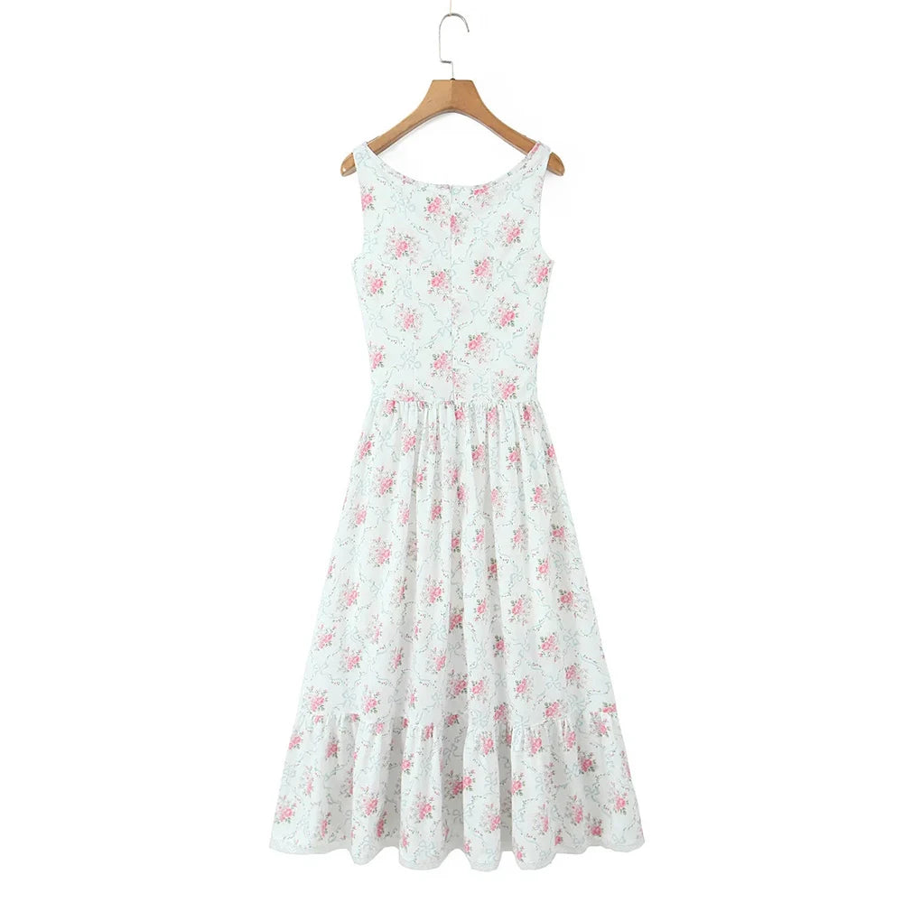 White dress with pink floral pattern on a wooden hanger against a white background