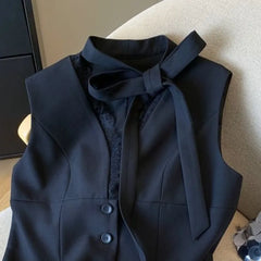 Dark blue vest with a bow tie on a chair
