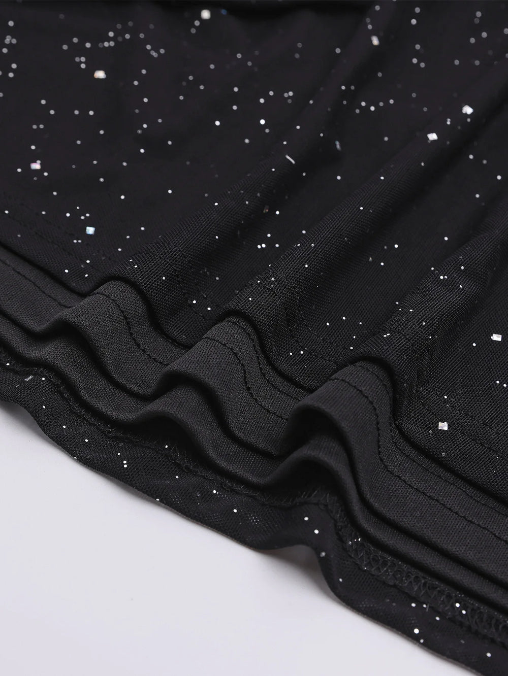 Close-up of black fabric with white speckles on a light gray background