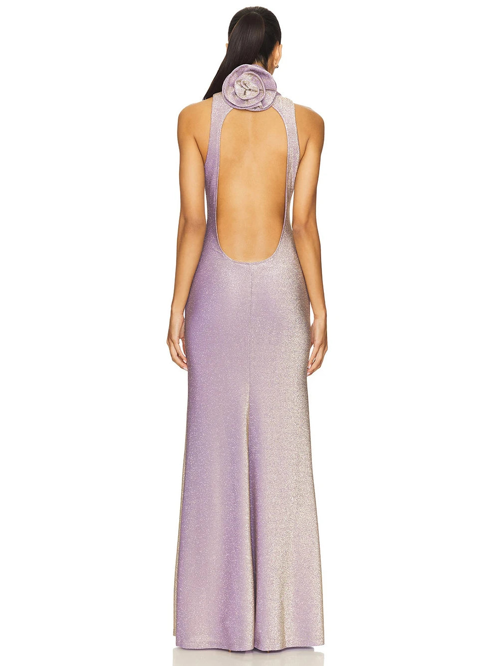 Woman wearing a long, open-back dress with a subtle pattern on a white background