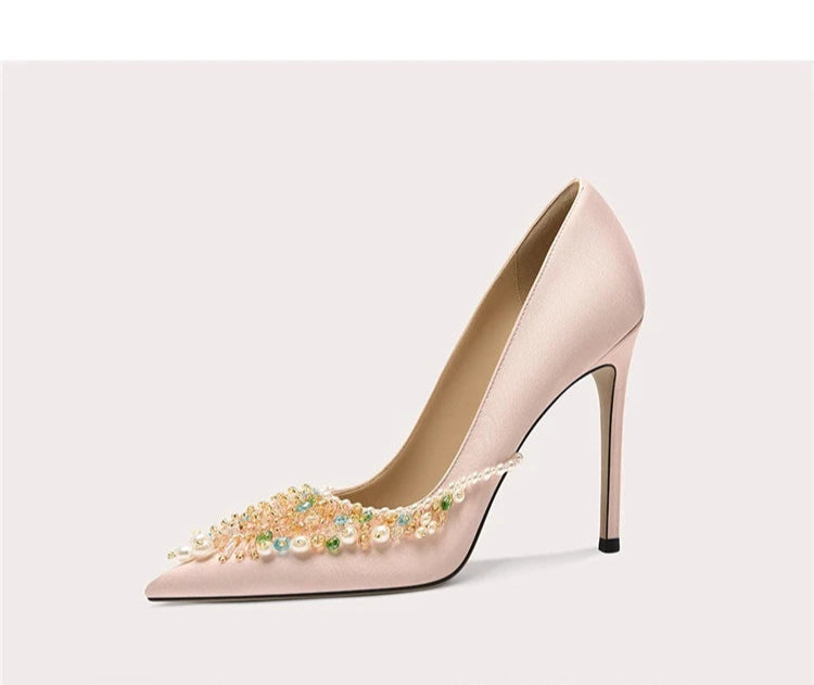 High-heeled shoe with decorative elements on a light gray background