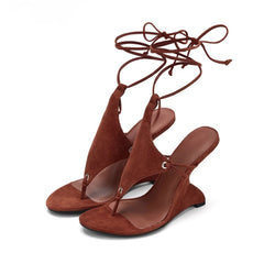 Brown suede sandals with tie-up straps on a white background