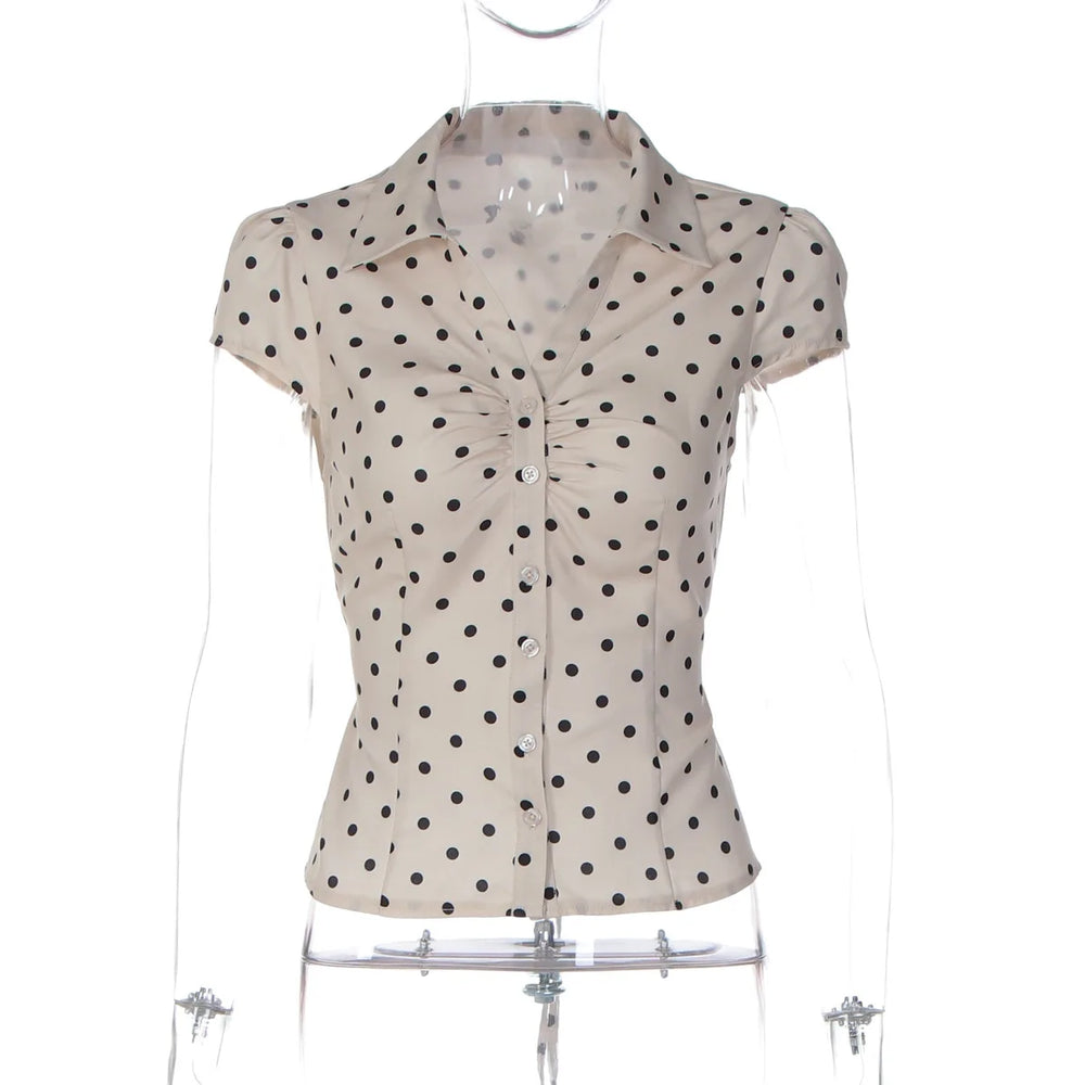 Polka dot blouse on a mannequin against a white background