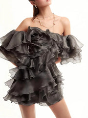 Black ruffled dress worn by a model on a white background