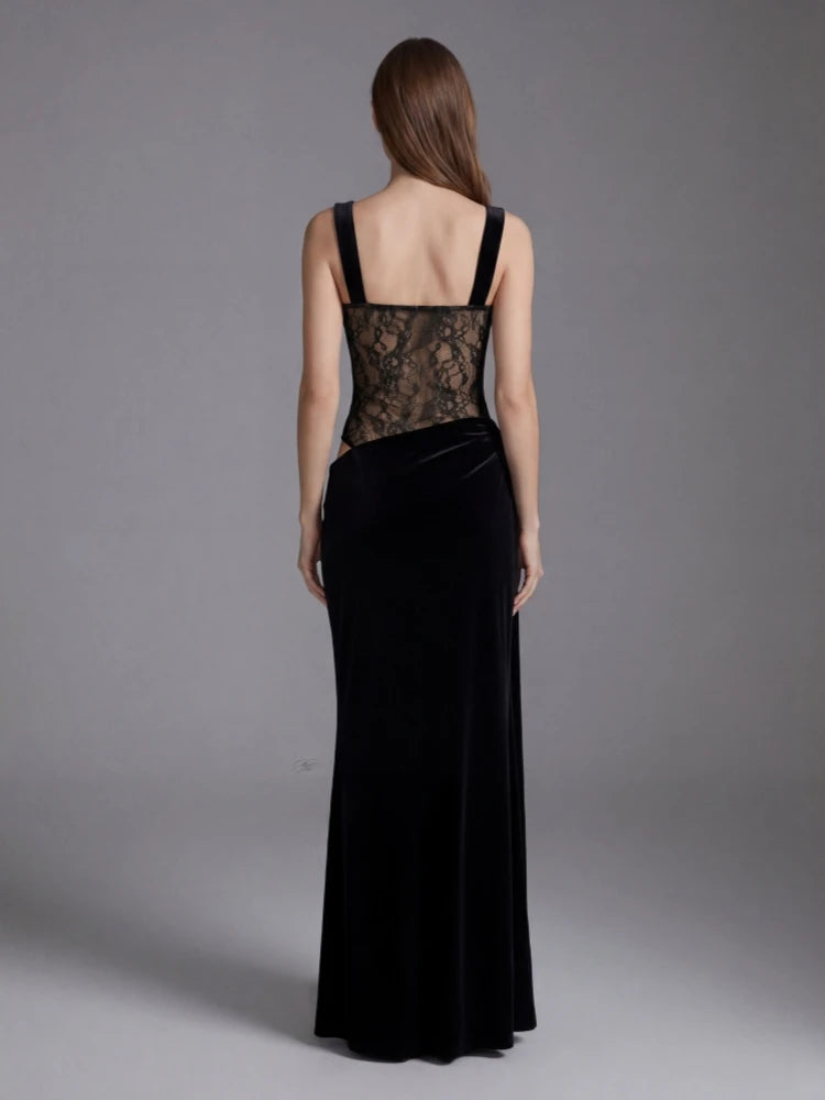 Woman wearing a black evening gown with lace detailing on a gray background