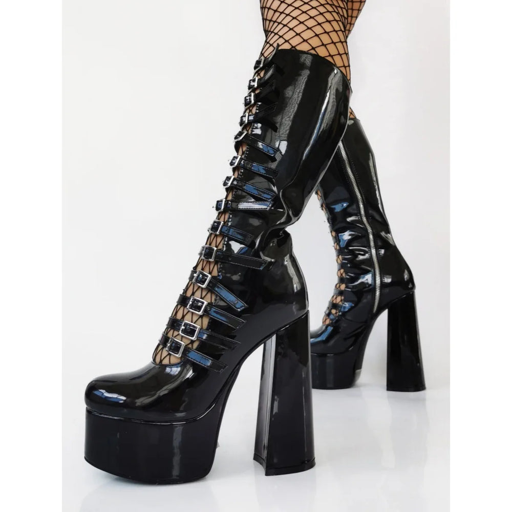 Black platform boots with high heels and detailed design on a white background