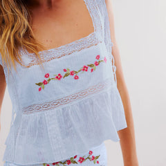 Light blue embroidered top with floral designs on a plain background