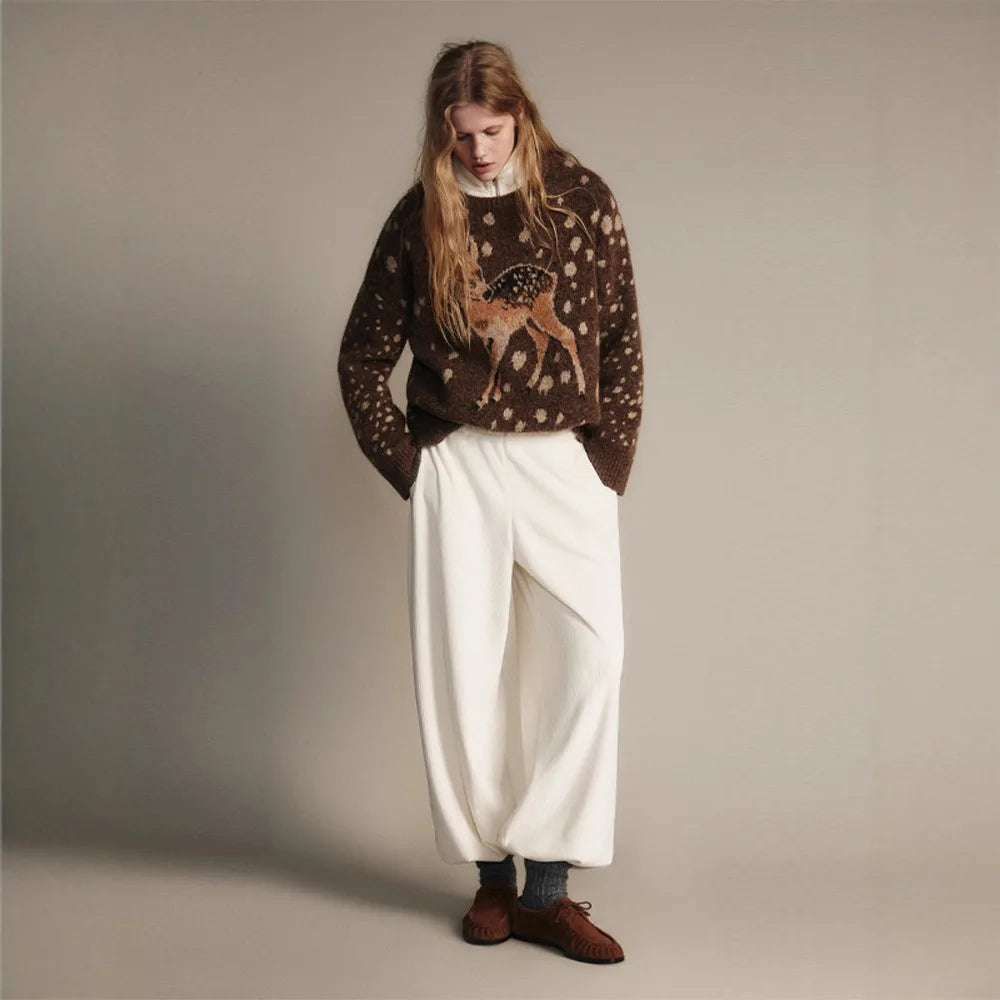 Model wearing dark brown crew neck knit sweater with fawn graphic print