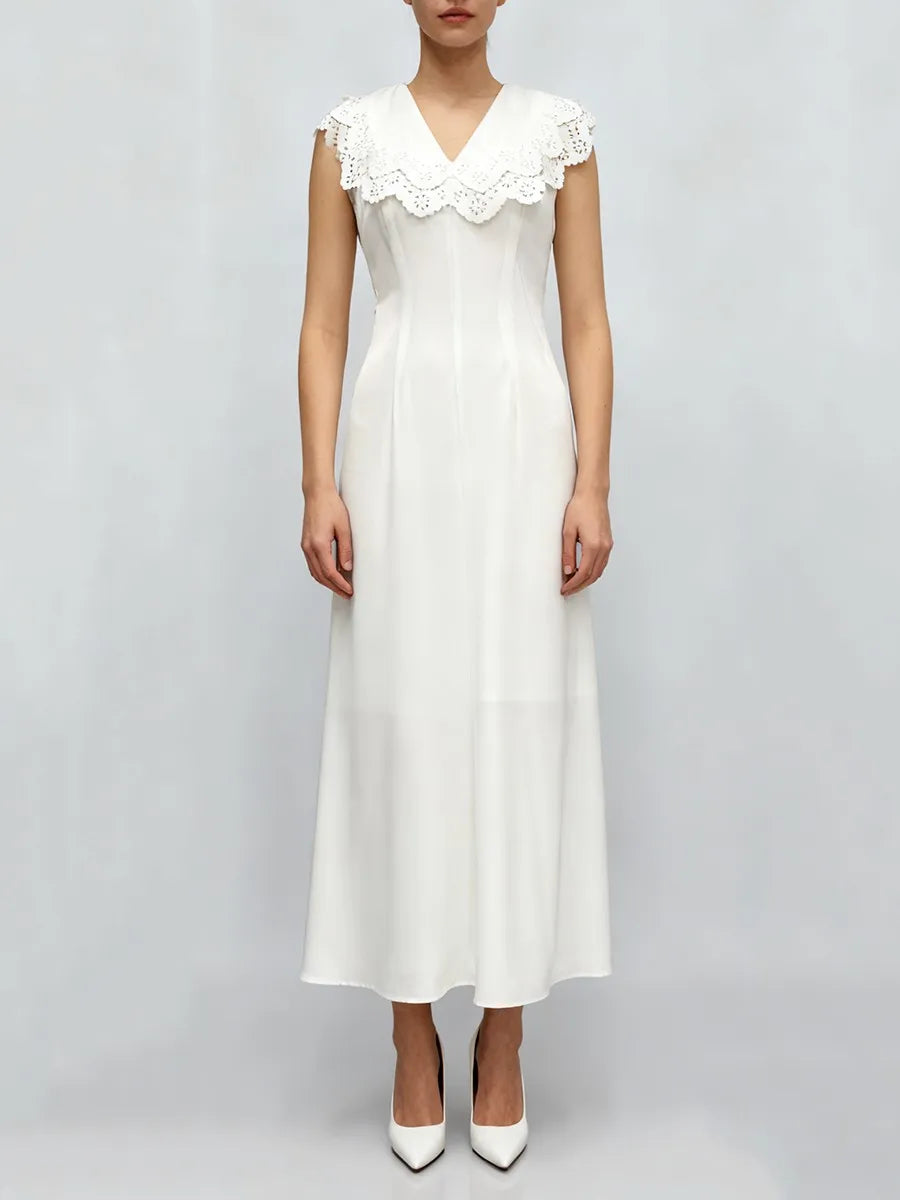 White dress with lace collar on a plain background