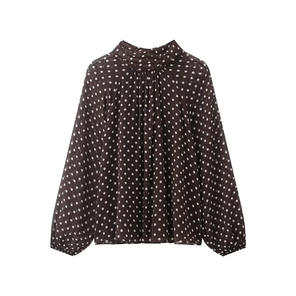 Black blouse with white polka dot pattern on a white background