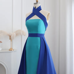  Mannequin displaying a glamorous royal blue evening gown with a contrasting turquoise overskirt and a criss-cross halter neckline. Golden Atelie4