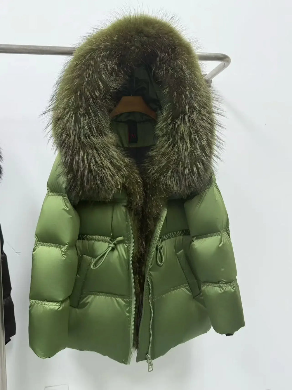Green puffer jacket with fur hood on a white background