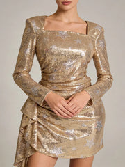 Gold sequin dress with long sleeves on a neutral background