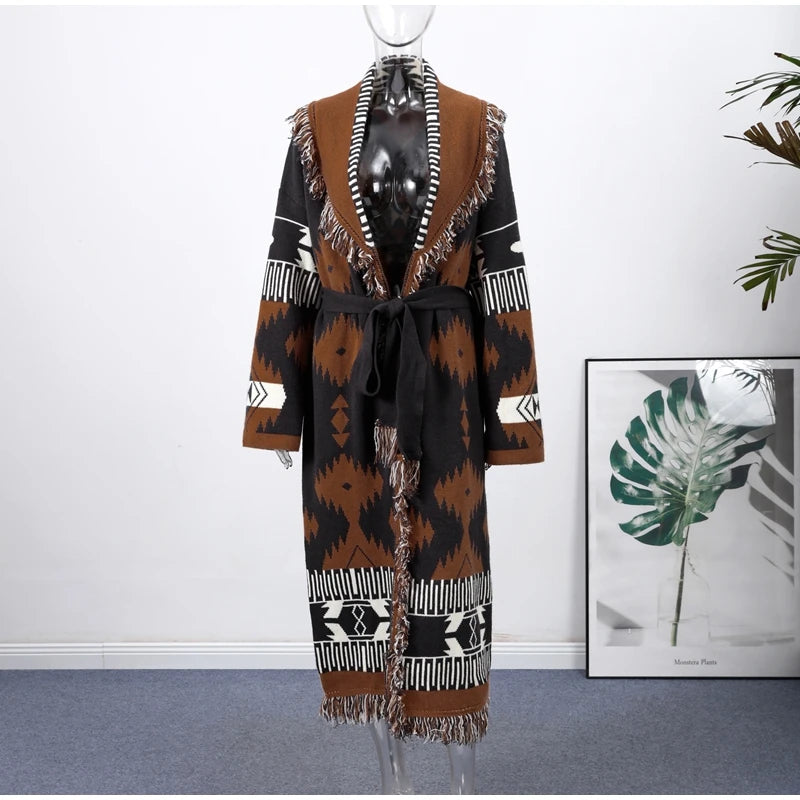 Mannequin wearing a patterned coat with a white wall and plant in the background