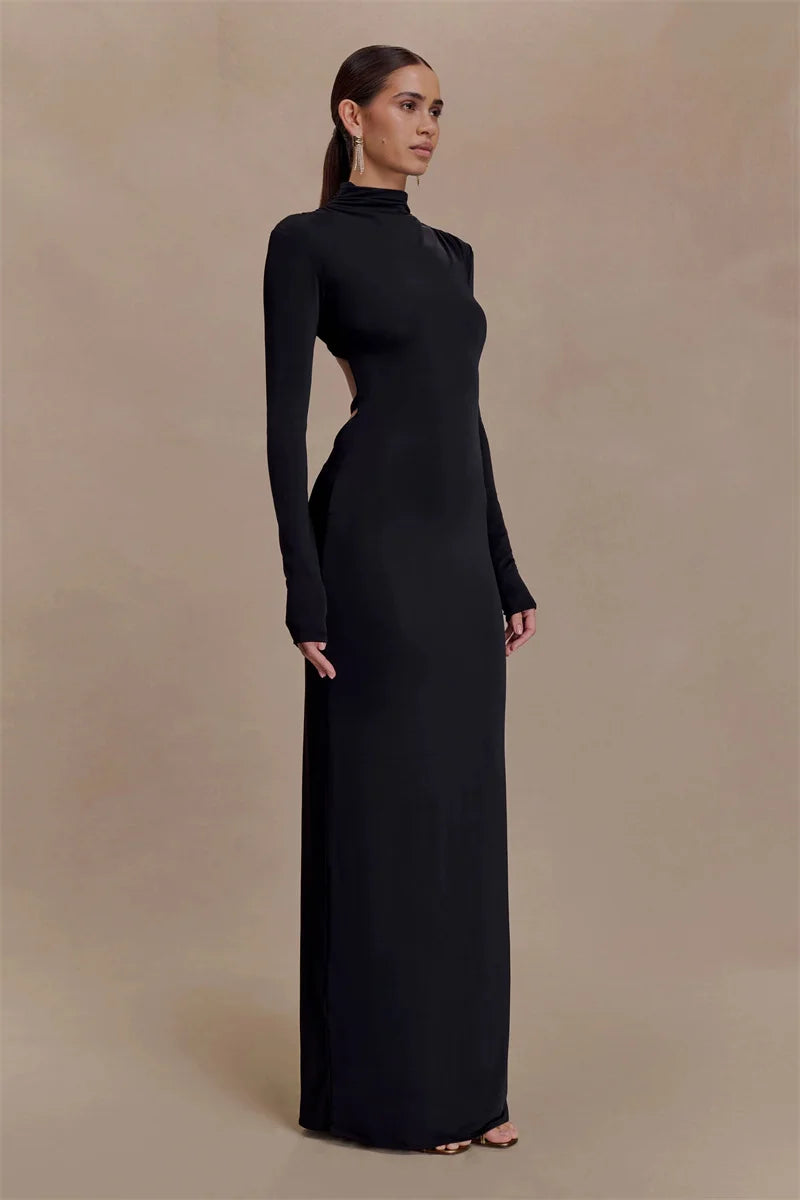 Woman wearing a black long-sleeve gown against a beige background