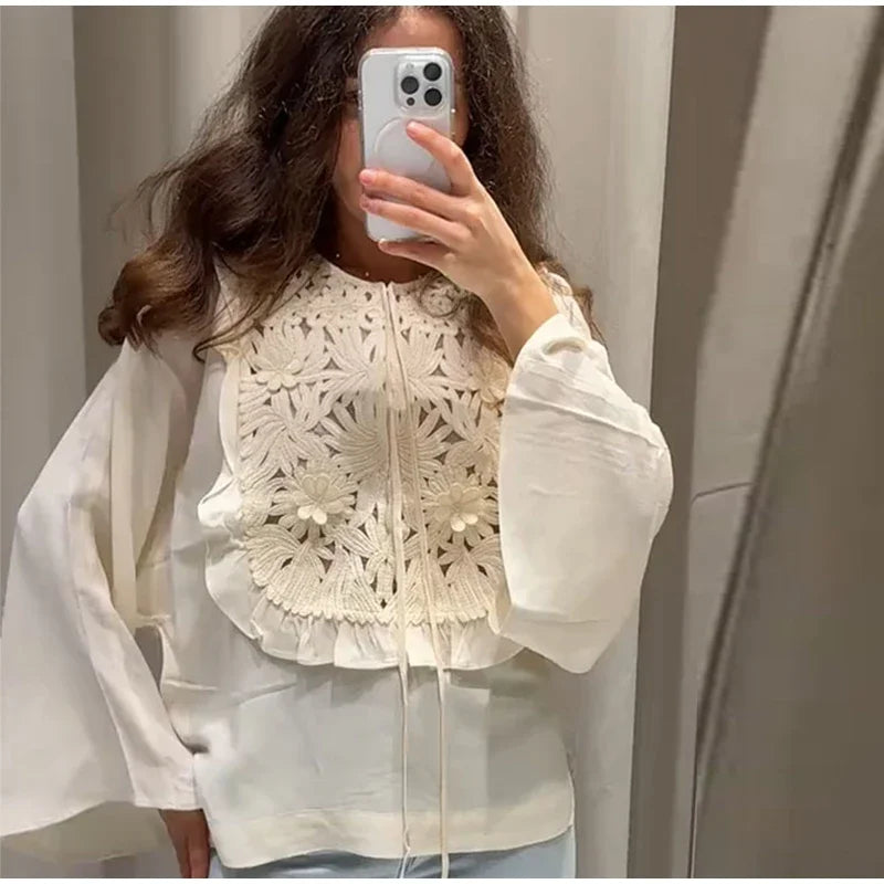 Floral embroidered blouse with flared sleeves and mini skirt detail.