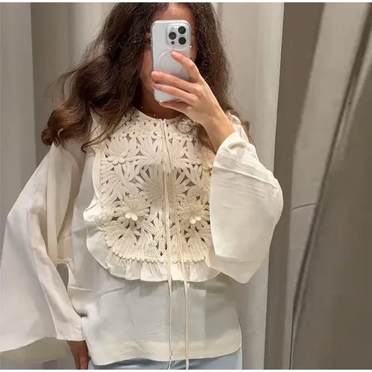Floral embroidered blouse with flared sleeves and mini skirt detail.