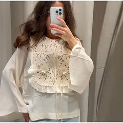 Floral embroidered blouse with flared sleeves and mini skirt detail.