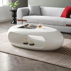 Modern living room with a white oval coffee table, gray sofa, and decorative items.
