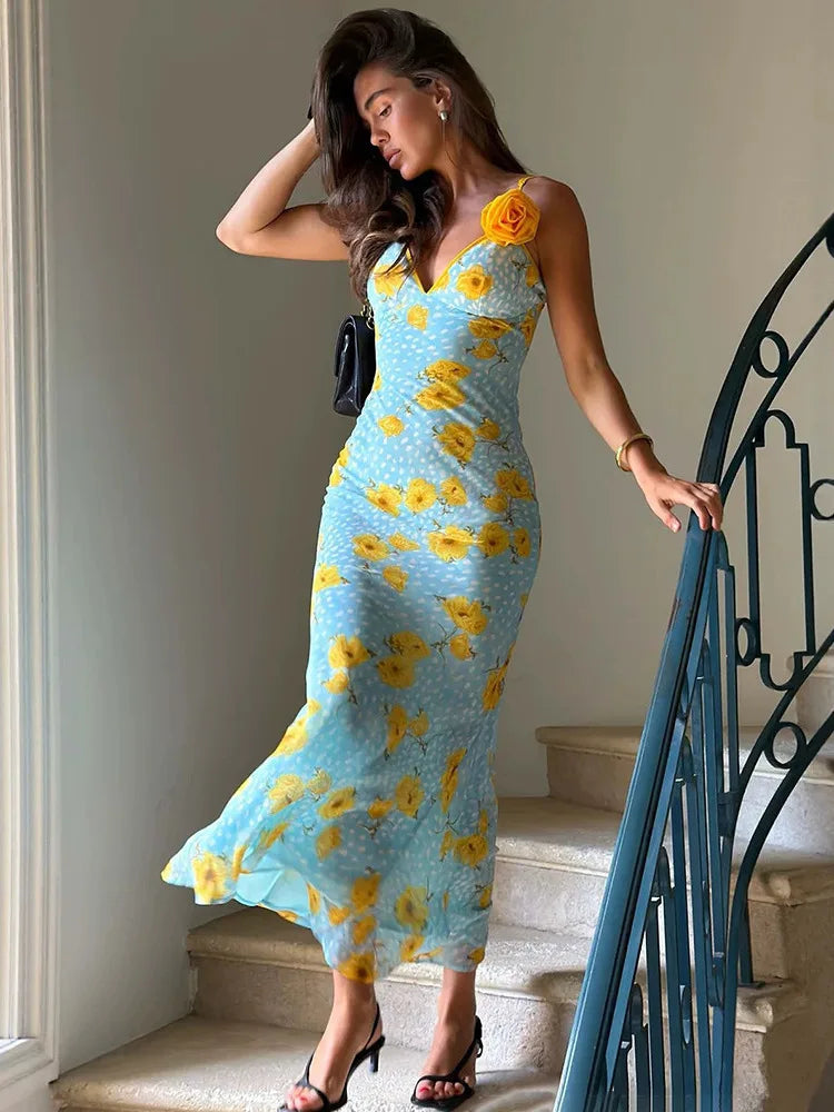 Maxi dress with sunflower print and spaghetti straps on stairs