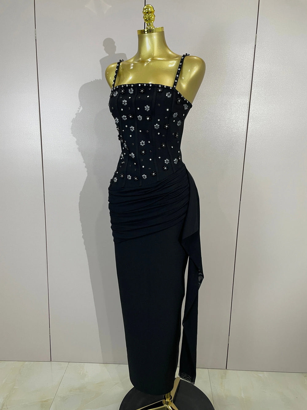 Close-up of the beaded embellishments on the bodice of a black spaghetti strap dress
