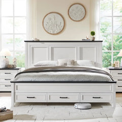 White bed with black accents in a bright bedroom with large windows.