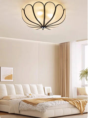 Ceiling light fixture in a bedroom with a bed and window in the background