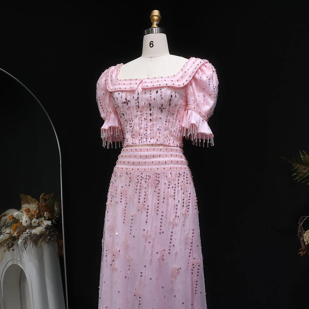 Pink dress with intricate detailing on a mannequin against a dark background