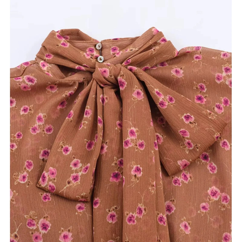 Close-up of floral print bow tie neck blouse neckline