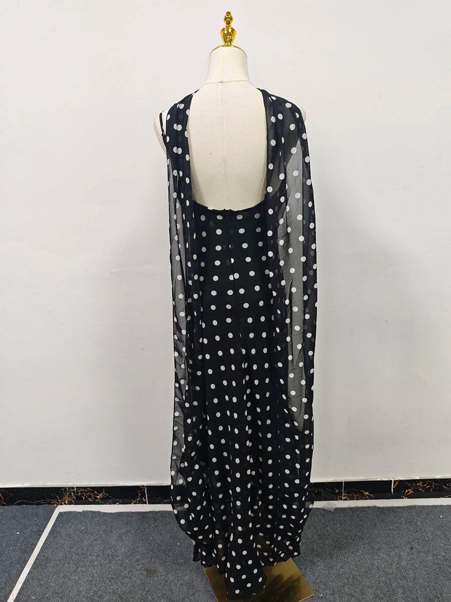 Black dress with white polka dots on a mannequin against a white background