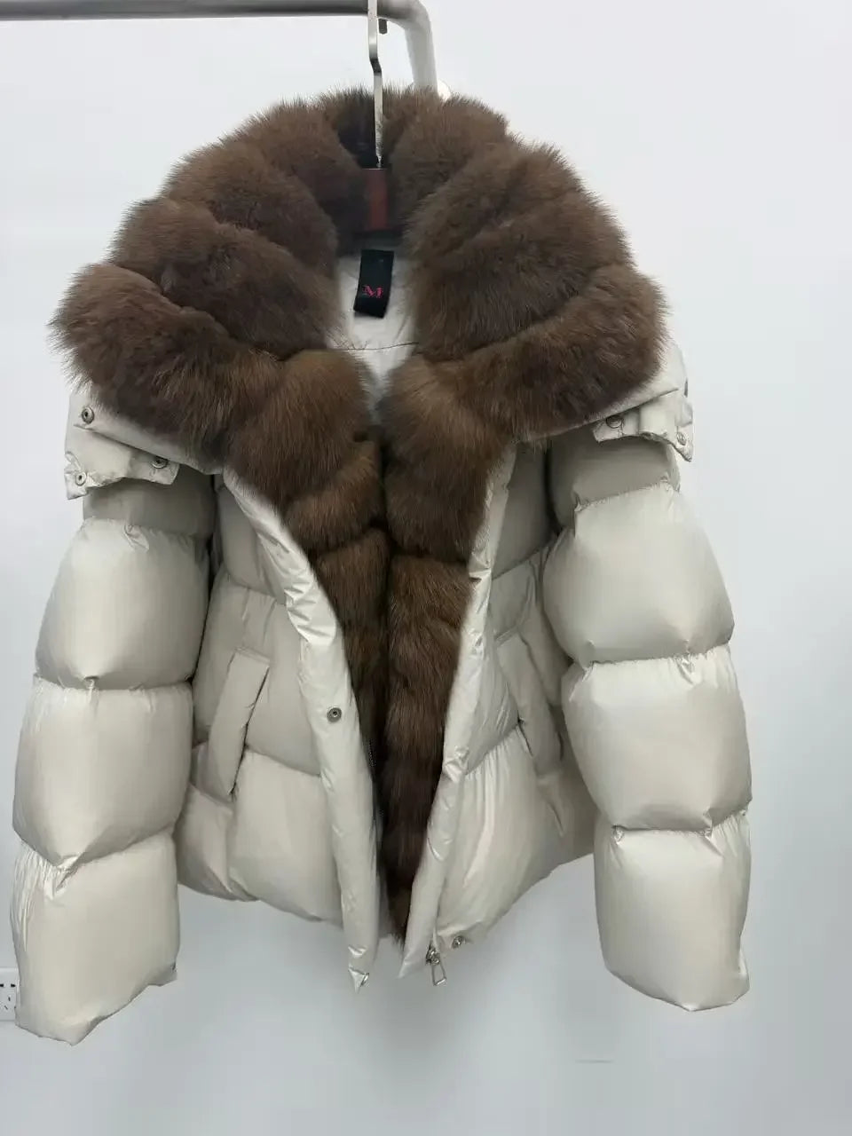 White puffer jacket with brown fur hood on a white background
