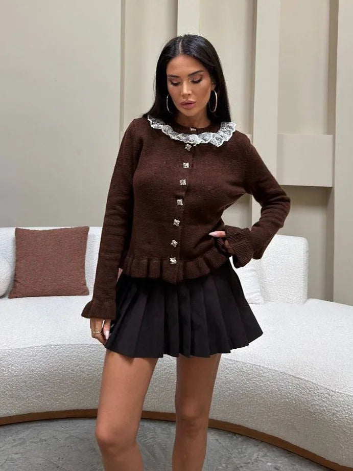 Woman wearing a brown cardigan and black skirt in an indoor setting