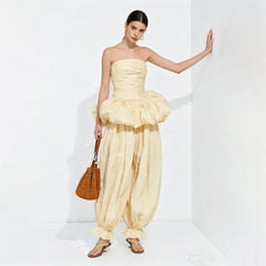 Strapless ruched top and balloon pants set leaning against wall