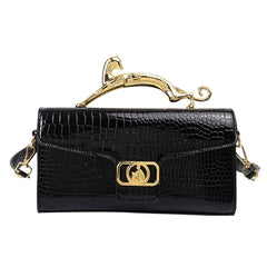 Black embossed top handle bag with gold animal accent