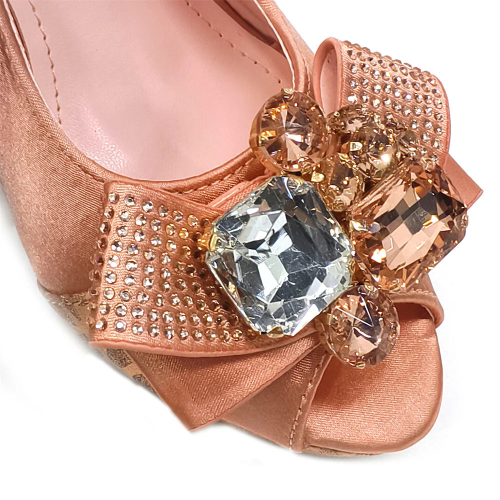 Rose gold shoe with decorative gemstones on a white background