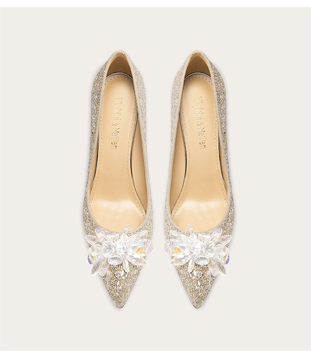 Pair of glittery high-heeled shoes with crystal accents on a light background