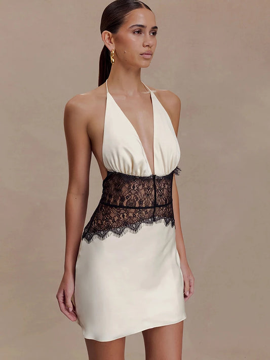 Close-up of black lace detail on white halter neck mini dress
