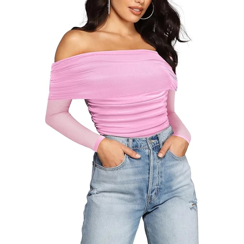Woman wearing a pink off-shoulder top and blue jeans on a white background