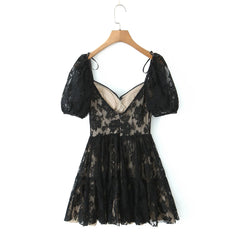 A black floral lace mini dress with puff sleeves and sweetheart neckline, styled for romantic summer evenings