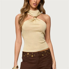 Woman wearing a beige halter top with a plain background