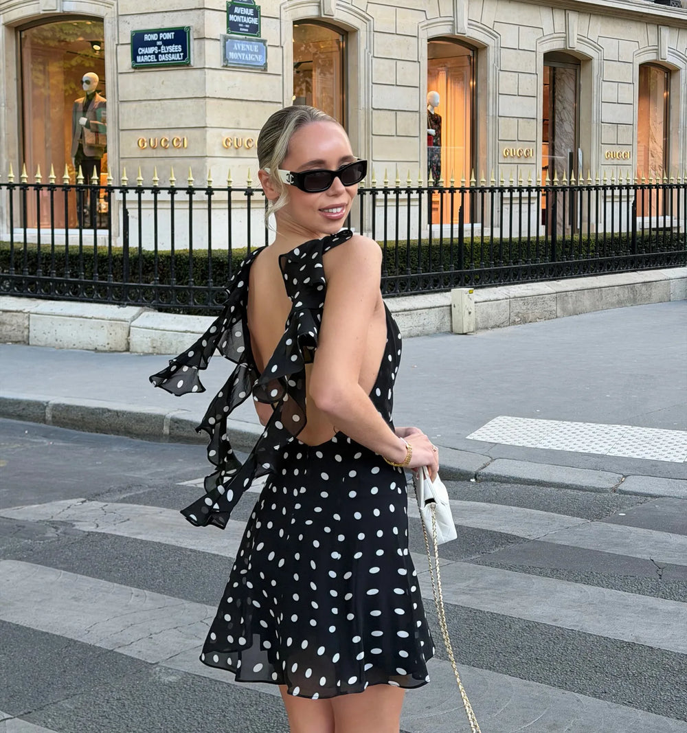 Back view of black polka dot mini dress with ruffle details