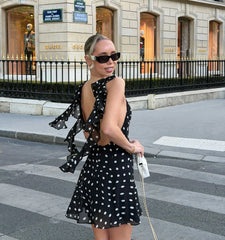 Back view of black polka dot mini dress with ruffle details