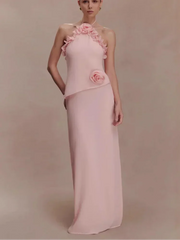 Pink evening gown with floral details on a plain background