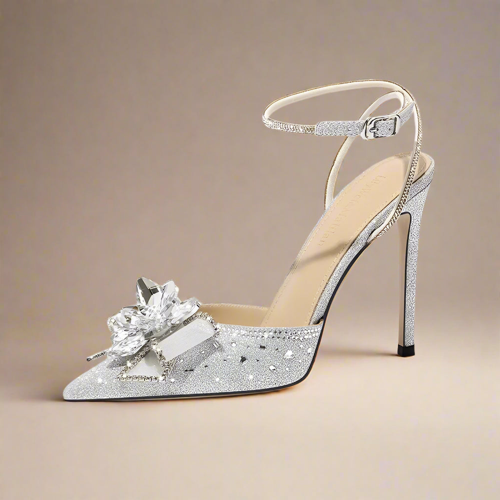Silver high-heeled shoe with decorative flower on a white background