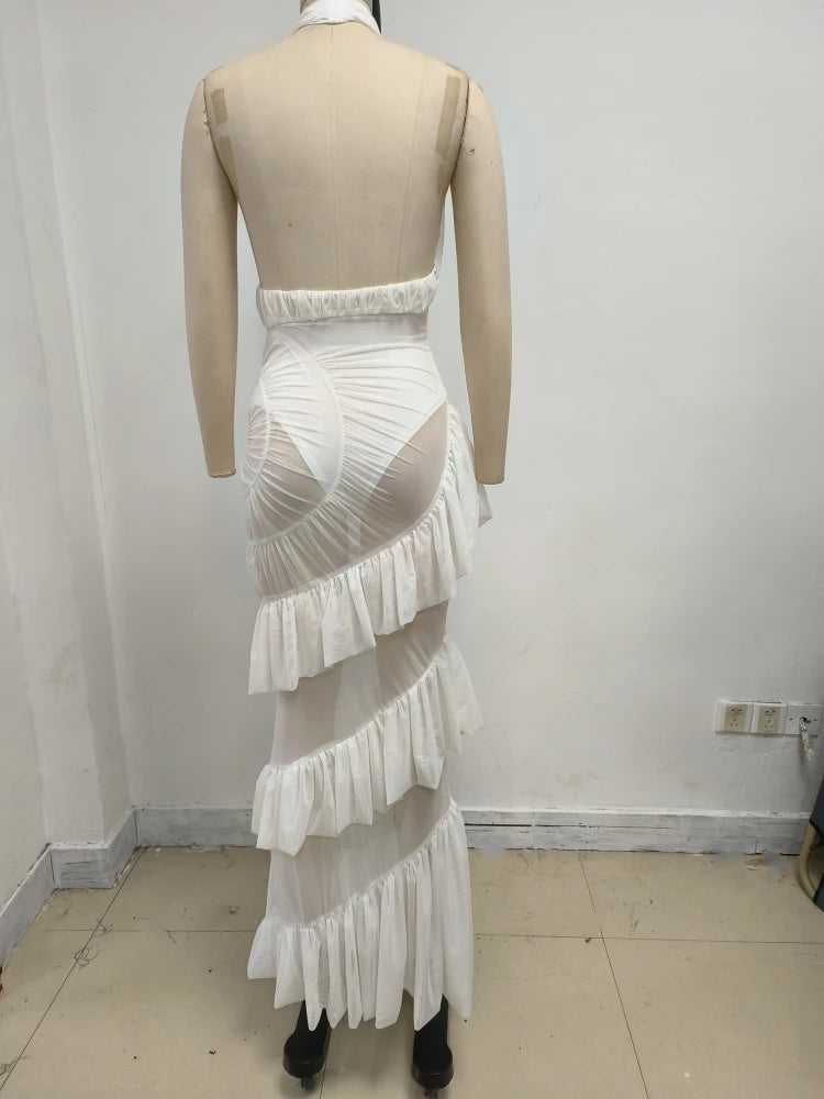 White ruffled dress on a mannequin against a plain wall.