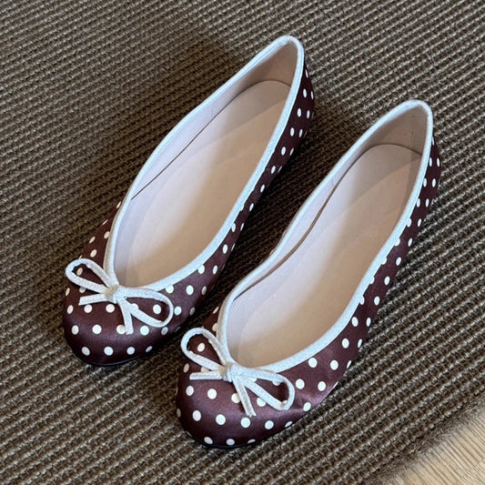 Brown polka dot ballet flats with white trim and a white bow