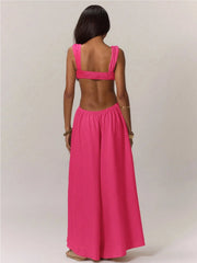 Woman wearing a bright pink jumpsuit against a plain background