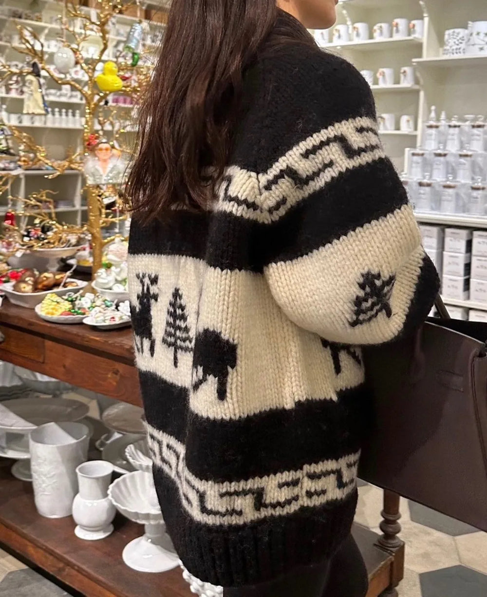 Person wearing a black and white patterned cardigan in a store setting