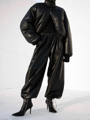 Person wearing a black leather outfit on a white background