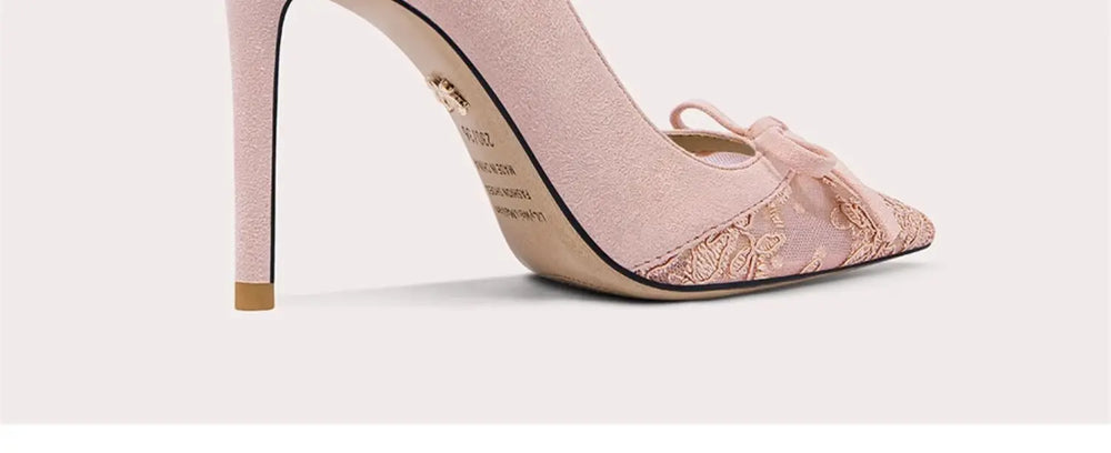 Pink high-heeled shoes with decorative bow on a white background